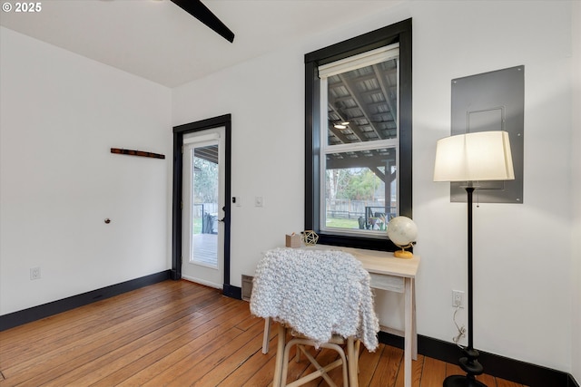 office with hardwood / wood-style floors, a ceiling fan, and baseboards