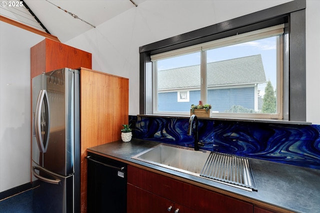 kitchen with dishwashing machine, dark countertops, and stainless steel fridge with ice dispenser