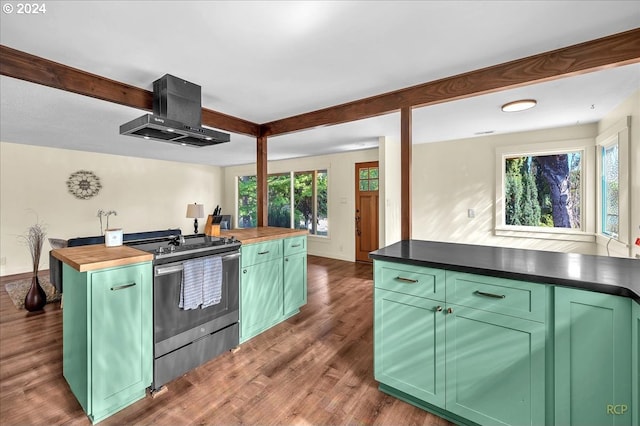 kitchen with dark wood-type flooring, green cabinets, stainless steel range, butcher block countertops, and ventilation hood