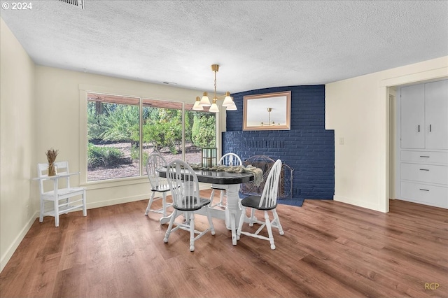 dining area with a textured ceiling and hardwood / wood-style floors