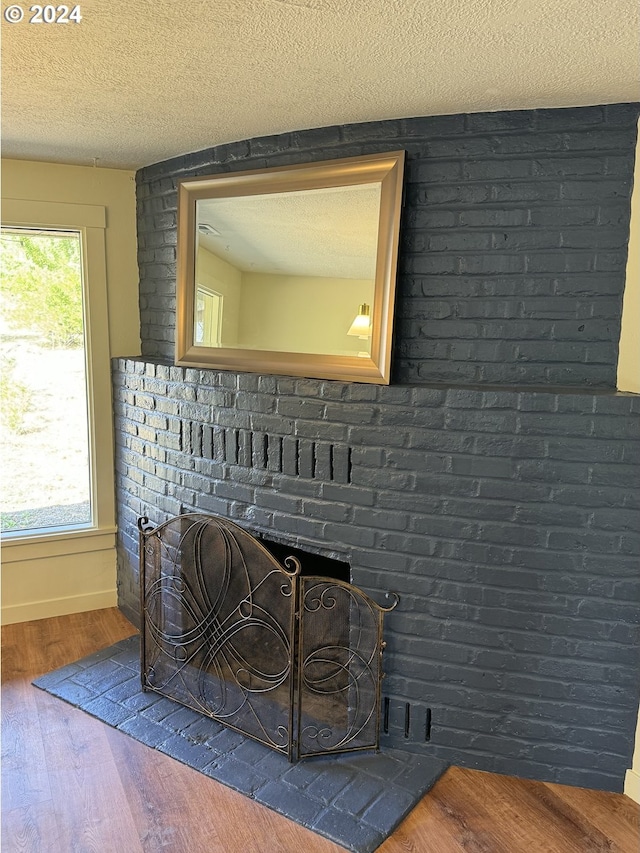 details with wood-type flooring, a fireplace, and a textured ceiling