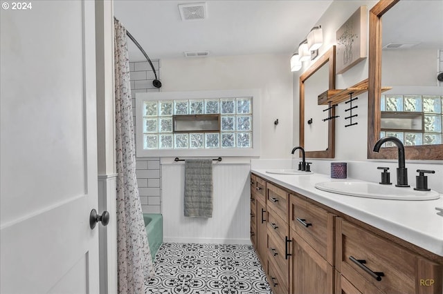 bathroom featuring plenty of natural light, tile patterned flooring, shower / tub combo, and vanity