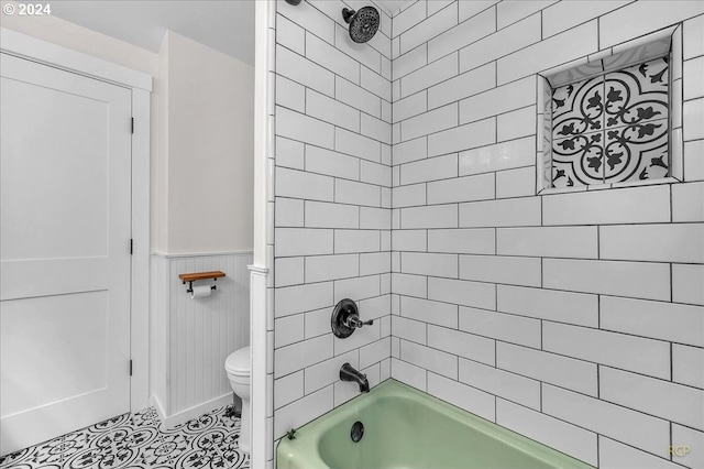 bathroom featuring toilet and tiled shower / bath