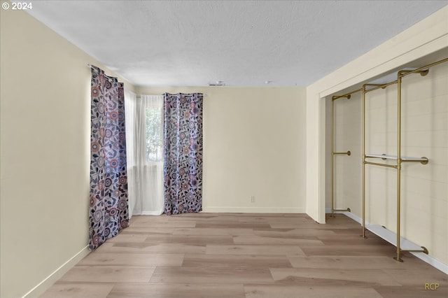 unfurnished bedroom with a textured ceiling and light hardwood / wood-style floors