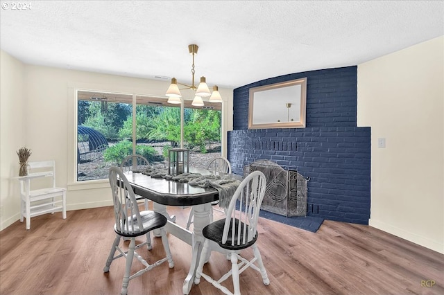 dining room featuring hardwood / wood-style flooring, a brick fireplace, and plenty of natural light