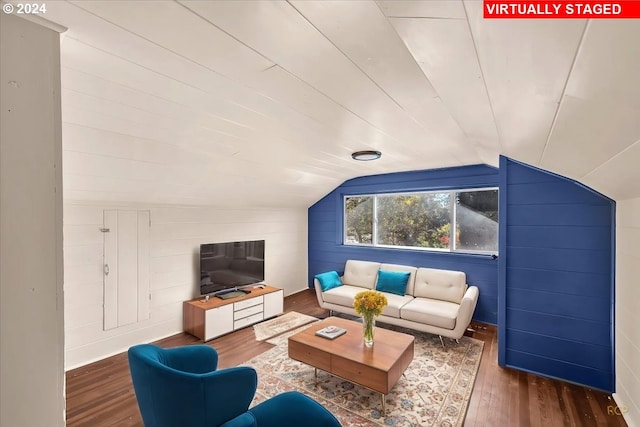 living room featuring lofted ceiling, wooden walls, and dark hardwood / wood-style flooring