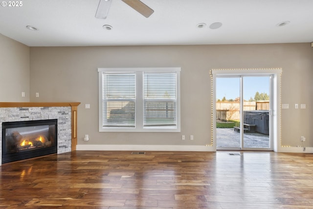 unfurnished living room with hardwood / wood-style floors, a fireplace, and ceiling fan