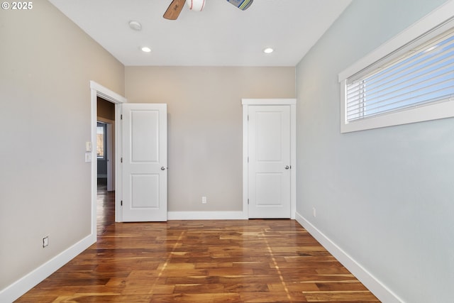 unfurnished bedroom with recessed lighting, wood finished floors, and baseboards