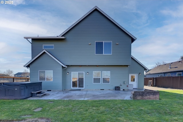 rear view of property featuring a yard, a hot tub, and a patio