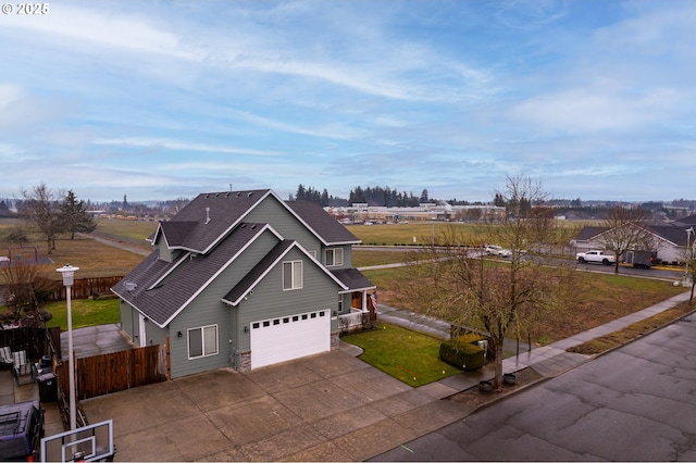 view of front of property with an attached garage, a shingled roof, fence, driveway, and a front yard