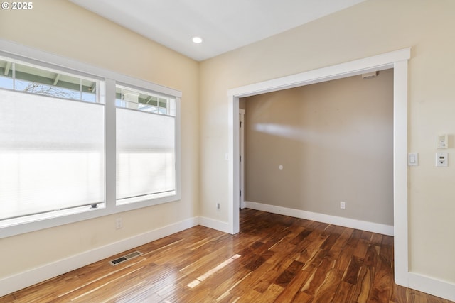 unfurnished room with recessed lighting, visible vents, baseboards, and wood finished floors