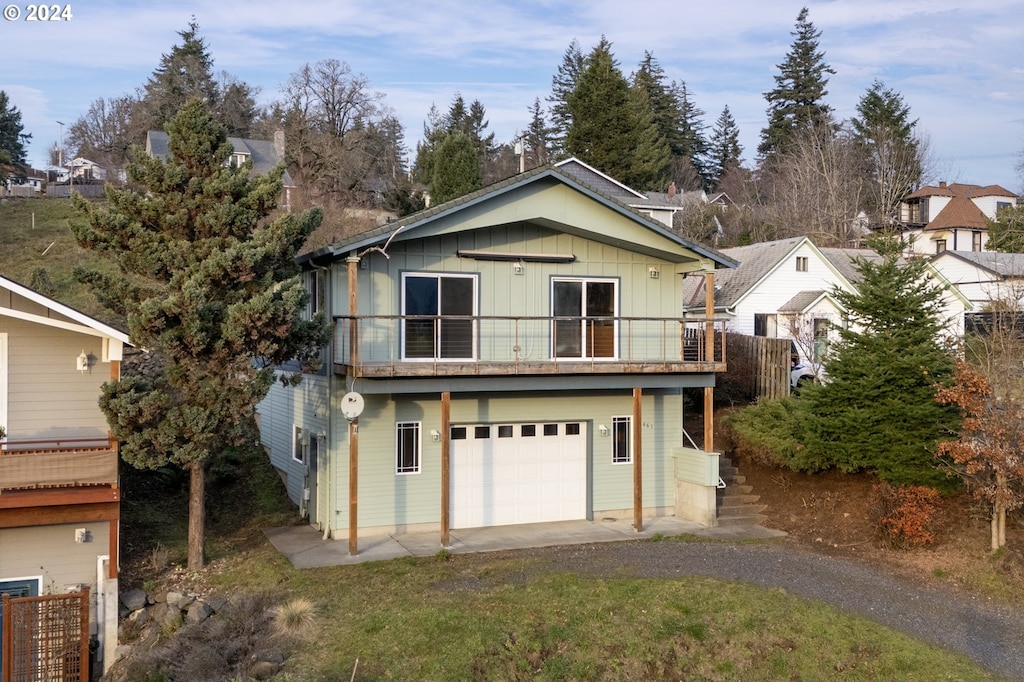 view of front property featuring a garage and a balcony