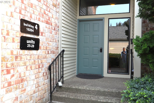 view of exterior entry featuring brick siding