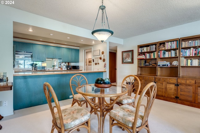 carpeted dining room with a textured ceiling