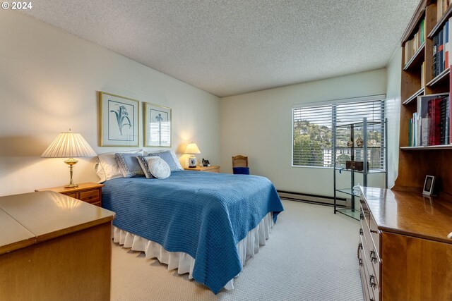 carpeted bedroom featuring a textured ceiling and a baseboard heating unit