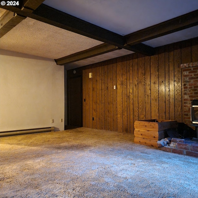 unfurnished living room with wooden walls, carpet flooring, beam ceiling, and a fireplace