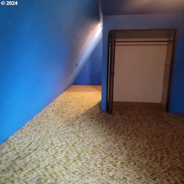 interior space featuring lofted ceiling and carpet flooring