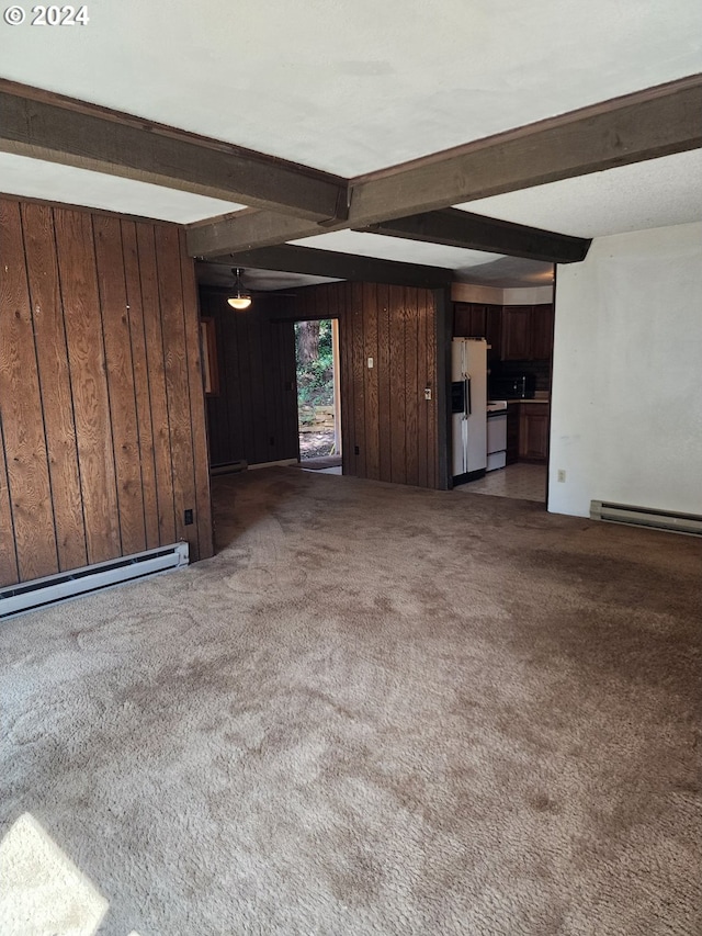 unfurnished living room with wood walls, dark colored carpet, and beamed ceiling