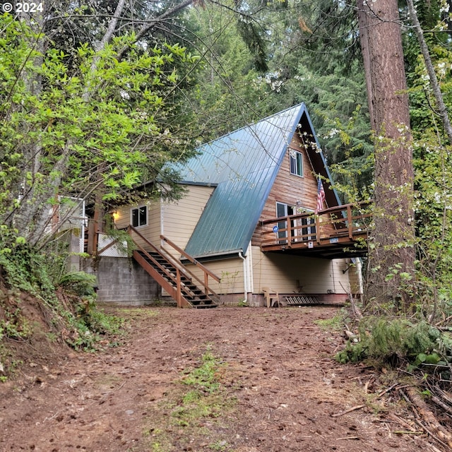 rear view of house featuring a wooden deck