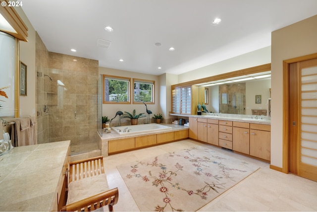 bathroom featuring recessed lighting, a sink, a shower stall, a bath, and double vanity