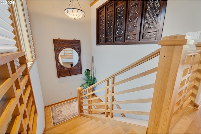 stairway with wood finished floors and baseboards