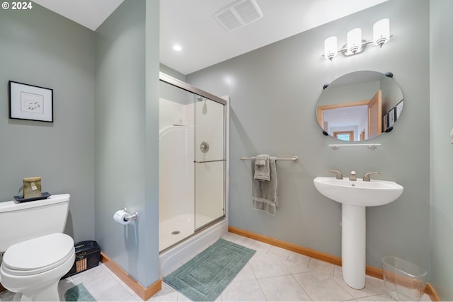 bathroom with toilet, tile patterned floors, and a shower with shower door