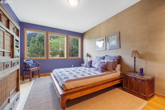 bedroom featuring light wood finished floors and baseboards