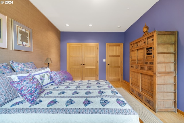 bedroom featuring light wood-type flooring, baseboards, a closet, and recessed lighting