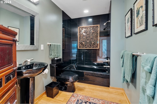 full bath with toilet, recessed lighting, wood finished floors, baseboards, and  shower combination