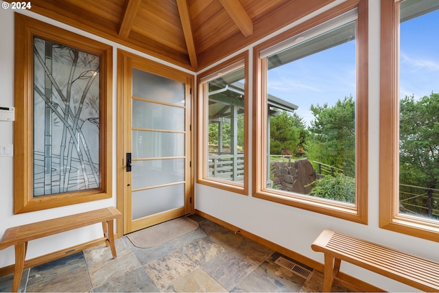 unfurnished sunroom featuring plenty of natural light, beamed ceiling, wooden ceiling, and visible vents