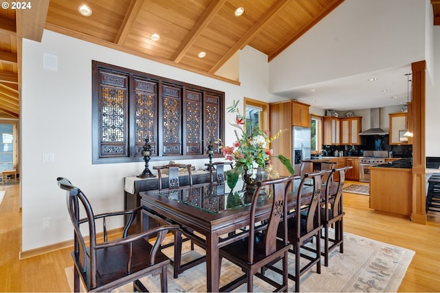 dining area with light hardwood / wood-style flooring, high vaulted ceiling, wooden ceiling, and beam ceiling