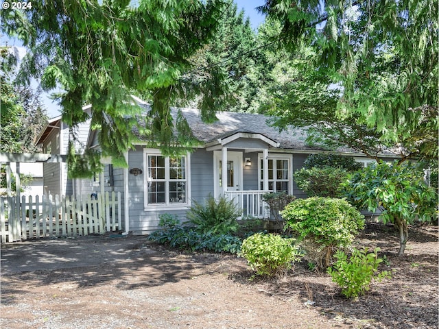 view of front of house featuring roof with shingles and fence