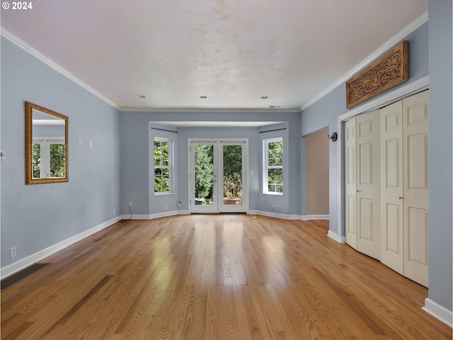 unfurnished bedroom featuring crown molding, french doors, and light wood-type flooring