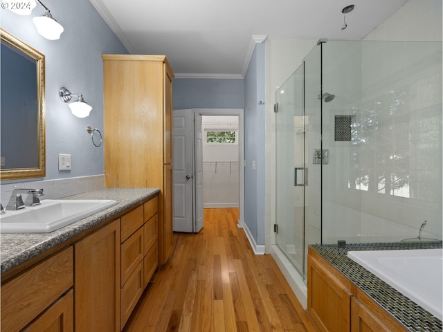 bathroom with hardwood / wood-style flooring, vanity, crown molding, and a shower with shower door