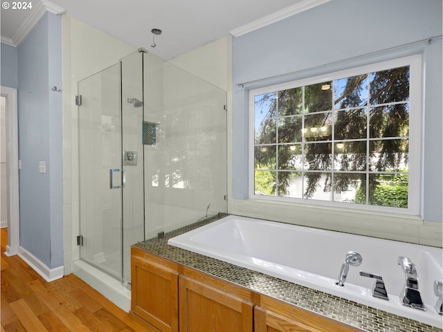 bathroom featuring hardwood / wood-style flooring, crown molding, independent shower and bath, and a healthy amount of sunlight