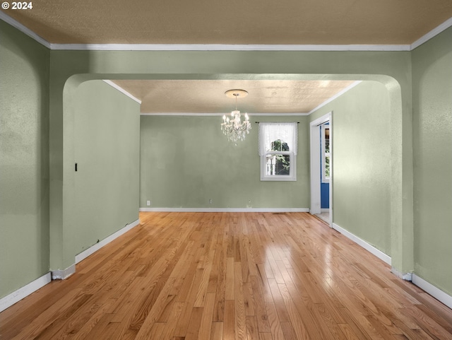 interior space featuring baseboards, light wood-style floors, an inviting chandelier, and crown molding