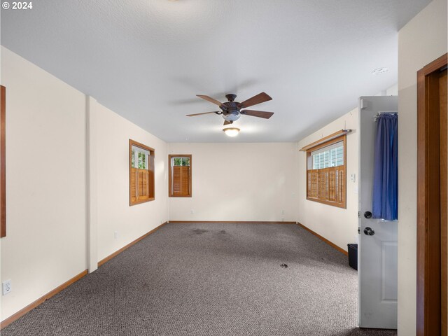 empty room with ceiling fan and carpet flooring