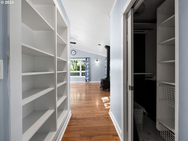 corridor featuring vaulted ceiling and wood-type flooring