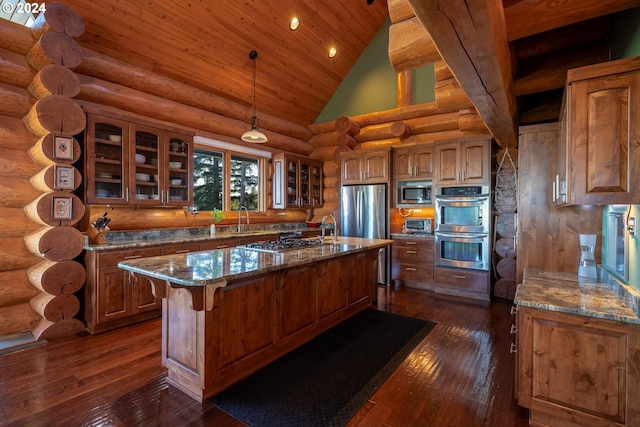 kitchen featuring stone countertops, a center island with sink, high vaulted ceiling, appliances with stainless steel finishes, and dark hardwood / wood-style floors