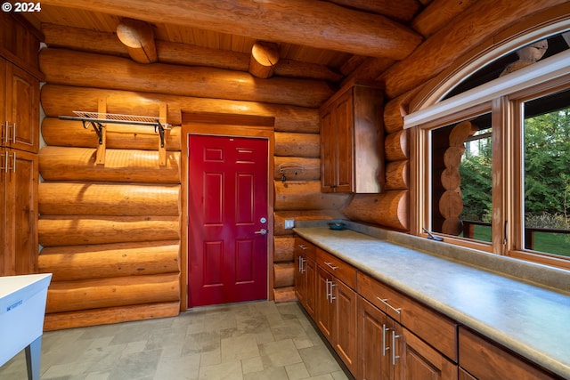 kitchen with beamed ceiling and log walls