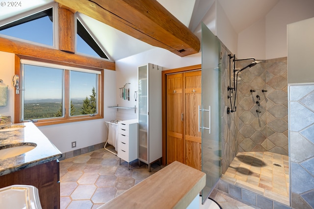 bathroom featuring vanity, lofted ceiling, and tiled shower