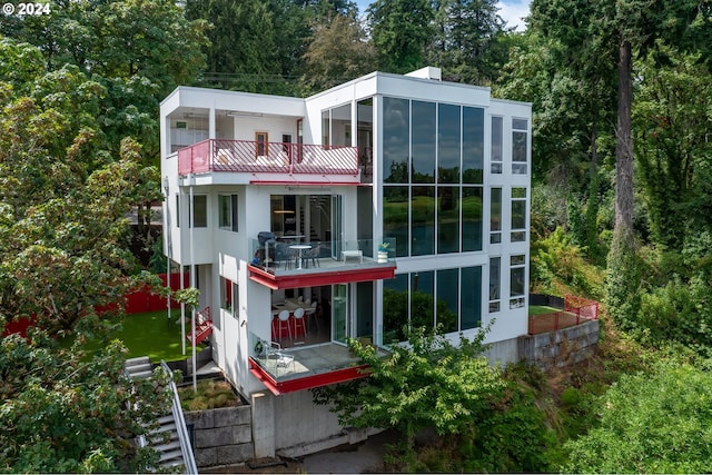 back of property featuring a balcony and a sunroom