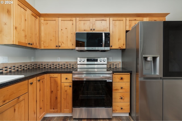 kitchen with dark countertops, appliances with stainless steel finishes, and dark wood-style flooring