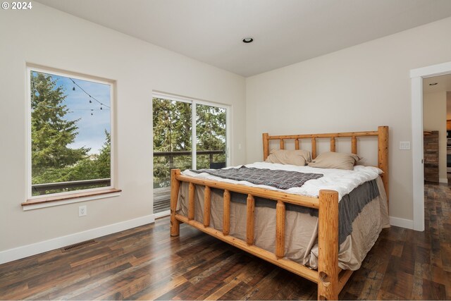 bedroom with dark wood-type flooring and multiple windows