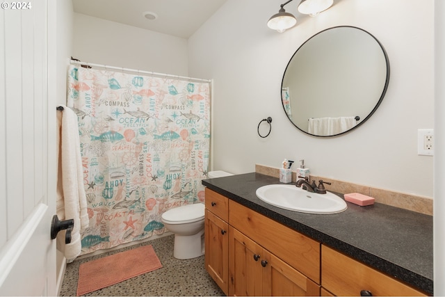 bathroom with toilet, a shower with curtain, vanity, and speckled floor