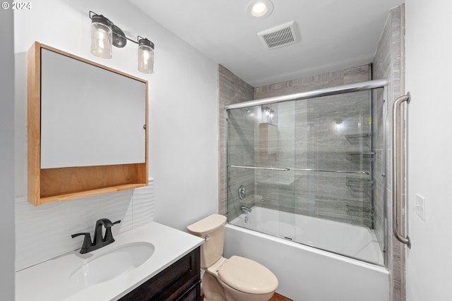 bathroom featuring visible vents, bath / shower combo with glass door, vanity, and toilet