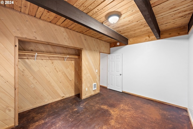unfurnished bedroom with visible vents, beam ceiling, wooden walls, wooden ceiling, and baseboards