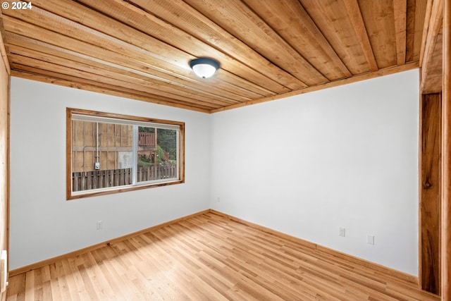 spare room with wooden ceiling, light wood-type flooring, and baseboards