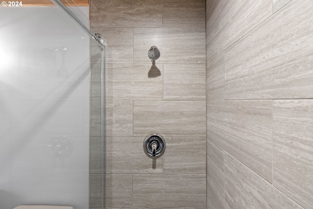 bathroom with toilet and tiled shower