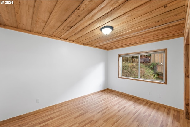 spare room with baseboards, wood finished floors, and wooden ceiling